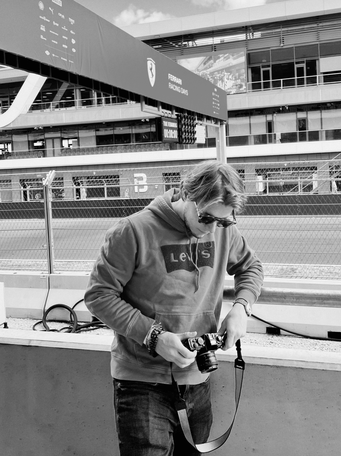 The photographer behind Vintage Vision at a racetrack, camera in hand